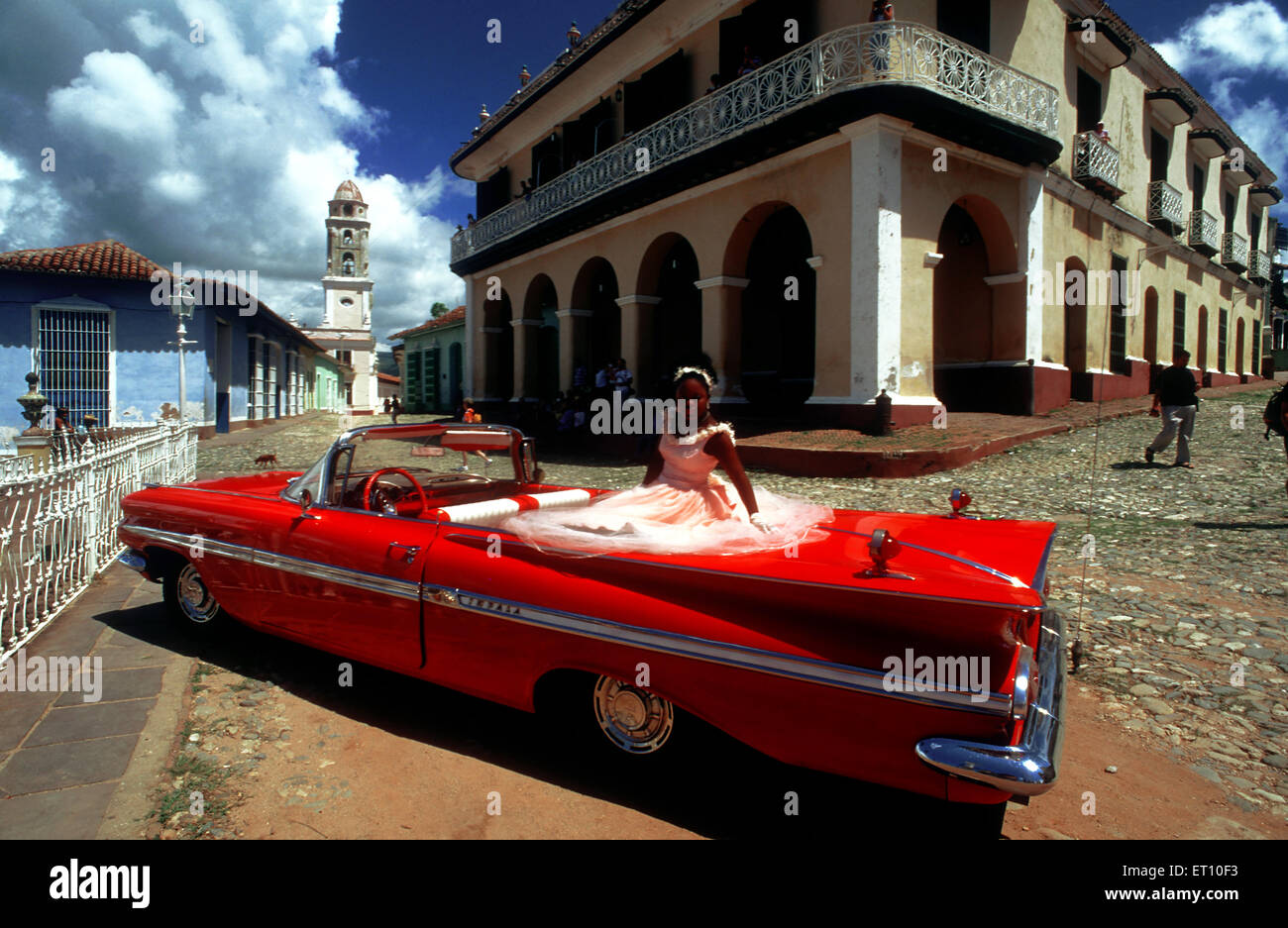 Junges Mädchen gekleidet für Quinceanera oder Quitte, die Feier des fünfzehnten Geburtstag eines Mädchens in Trinidad, Kuba, Karibik. Klassische rote 1959 schönen Chevy Cabrio auf Kopfsteinpflaster von Trinidad Kuba ein altes koloniales Dorf Stockfoto