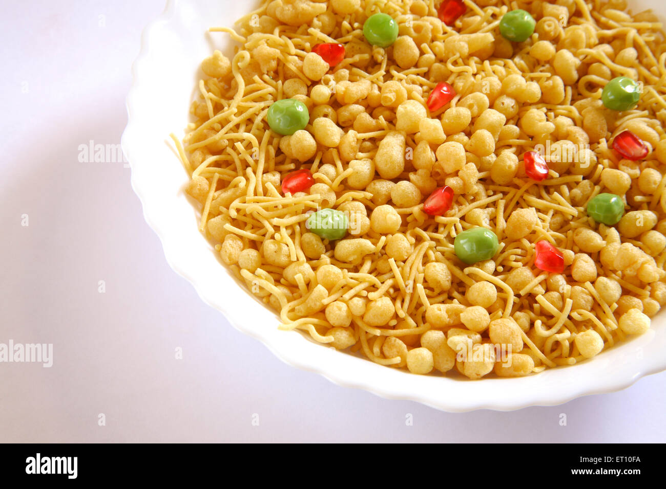 Snacks; Boondi Bhel Namkeen herzhaft garniert mit grünen Erbsen und Granatapfel in Runde Schale auf weißem Hintergrund Stockfoto