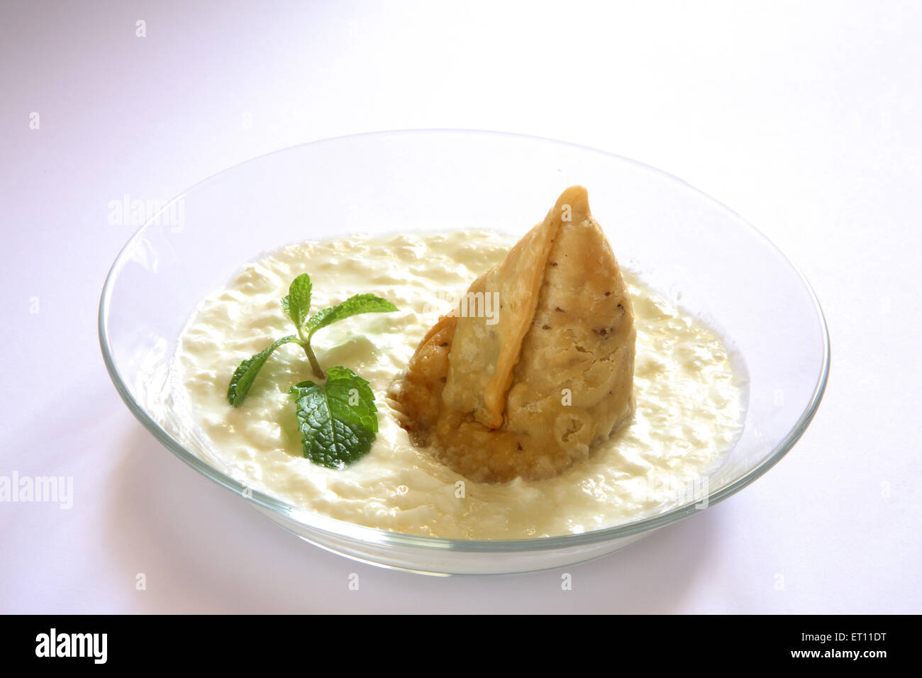 Fast-Food; Samosa mit Quark und Minze Blätter in Schüssel auf weißem Hintergrund Stockfoto