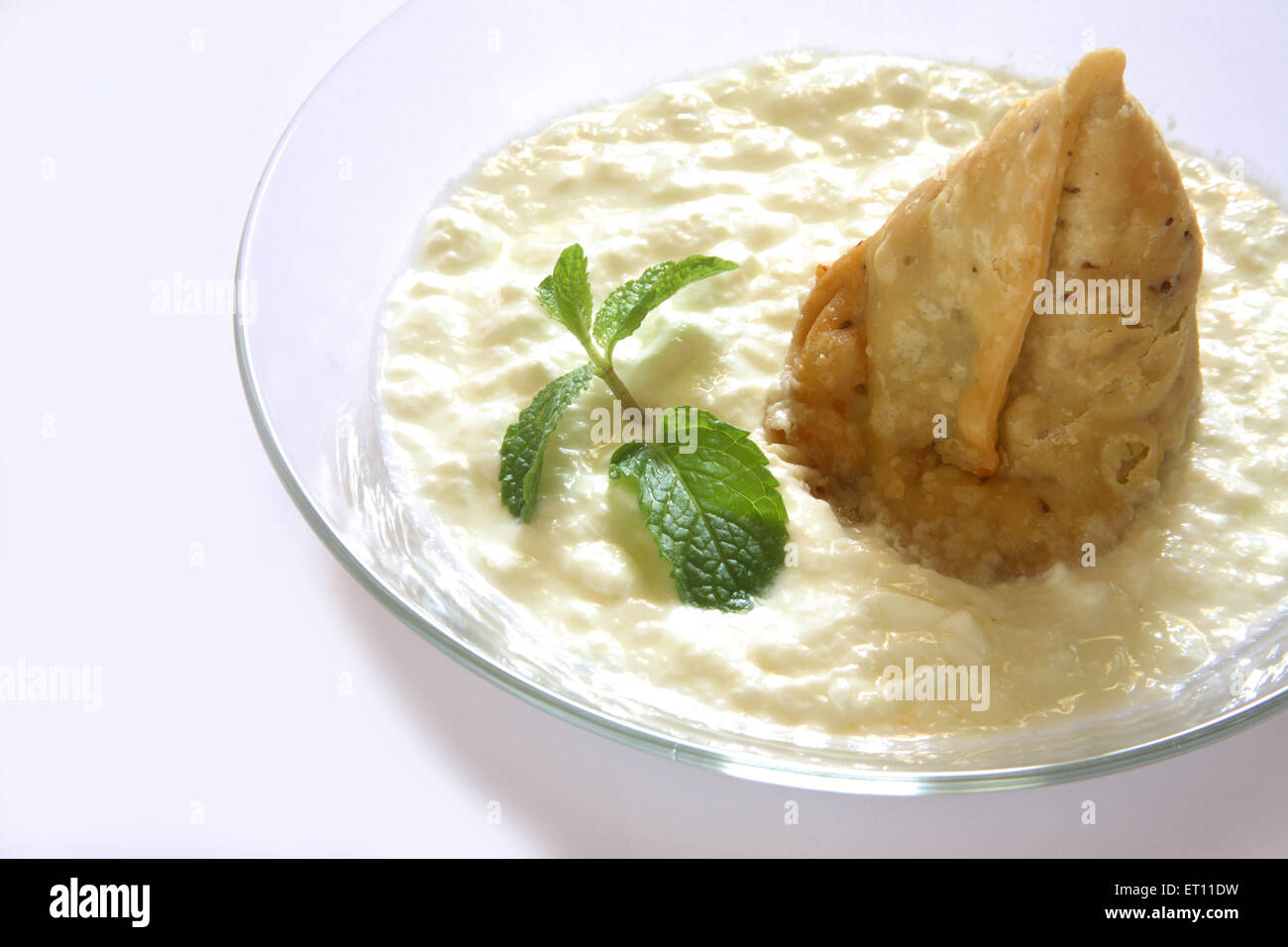 Fast-Food; Samosa mit Quark und Minze Blätter in Schüssel auf weißem Hintergrund Stockfoto