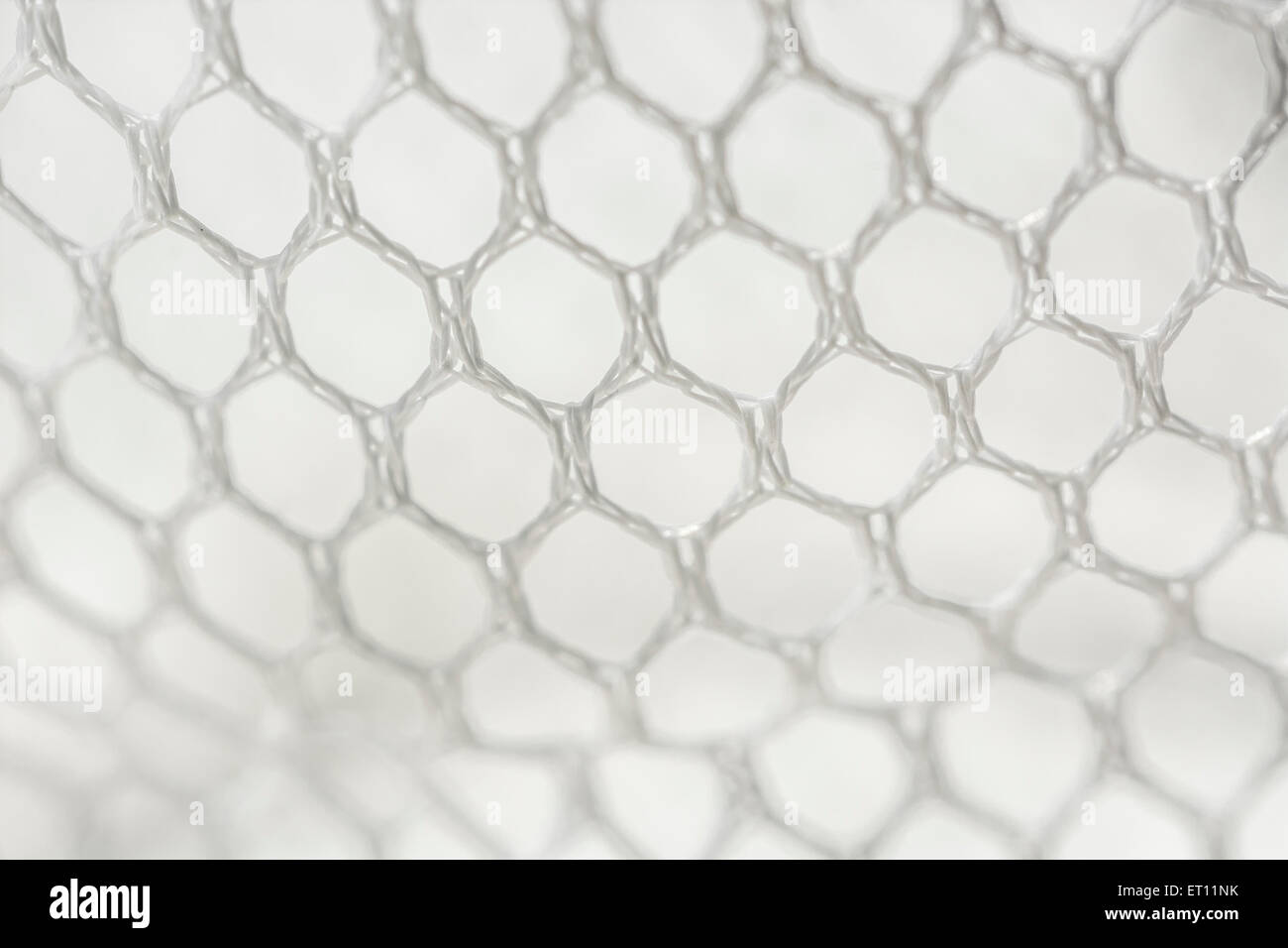 Makro - Foto von feinen weißen gewebten Polyester Mesh/Verrechnung gegen - weißer Hintergrund. Löcher ca. 4mm im Durchmesser. Stockfoto