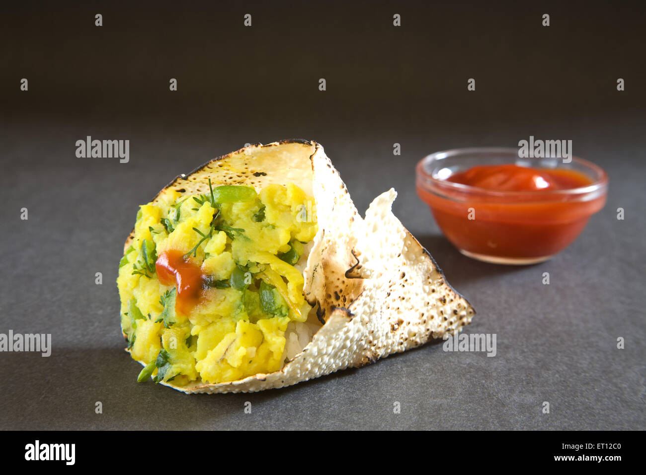 Gebratener Papad, Papadum, Papadom, indischer Snack, Cracker, Kartoffelfüllung, Tomatenketchup, Kegelform, schwarzer Hintergrund Stockfoto