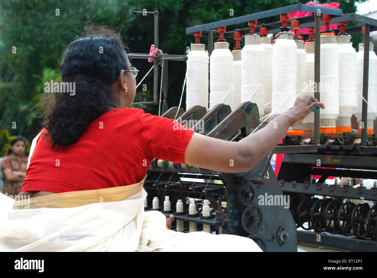 Frau, die Spinning Webstuhl macht Baumwollfaden; Trivandrum; Thiruvananthapuram; Kerala; Indien Stockfoto