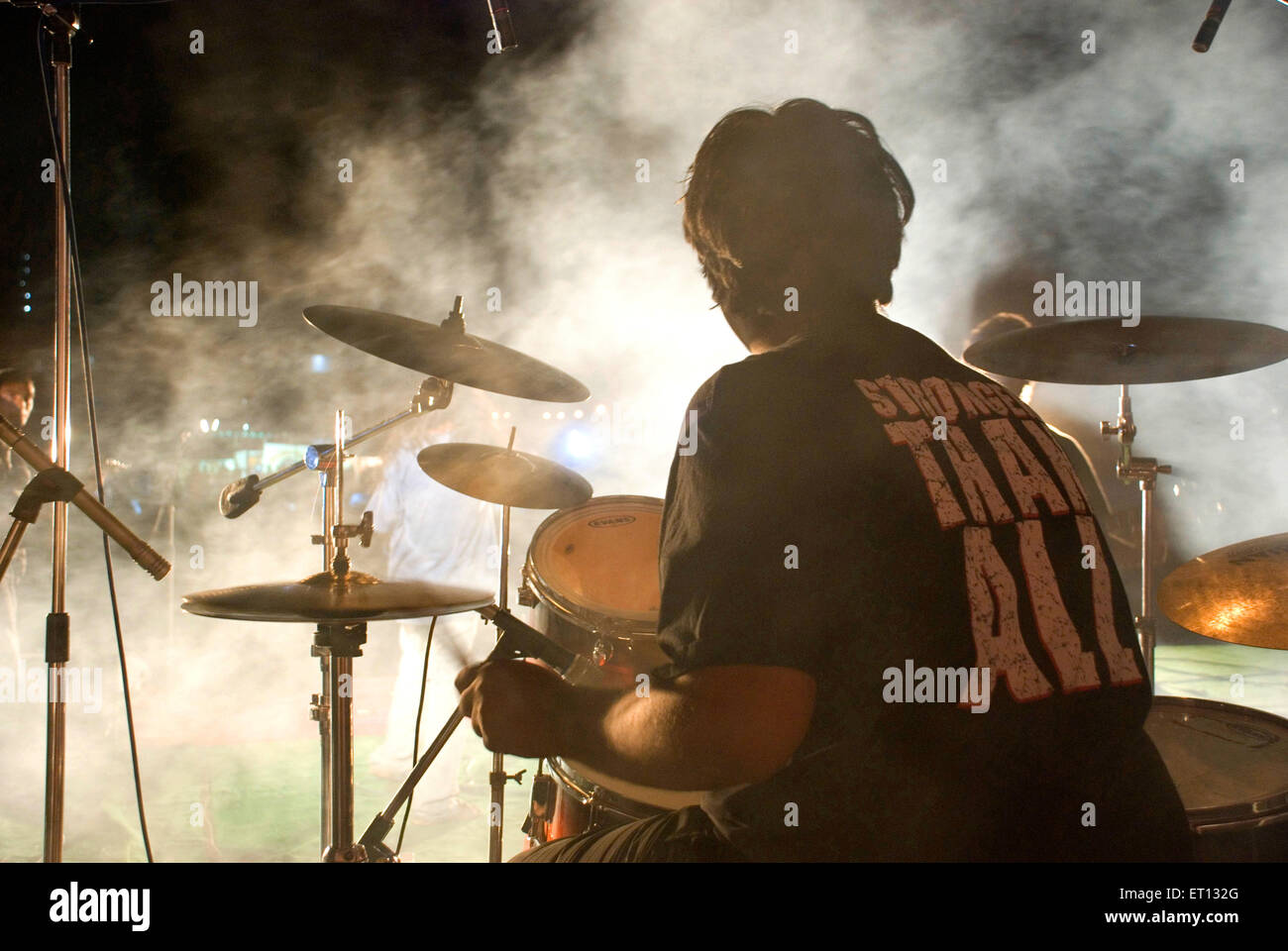 Rockshow-Schlagzeuger, der Schlagzeug mit Musikinstrumenten spielt Stockfoto