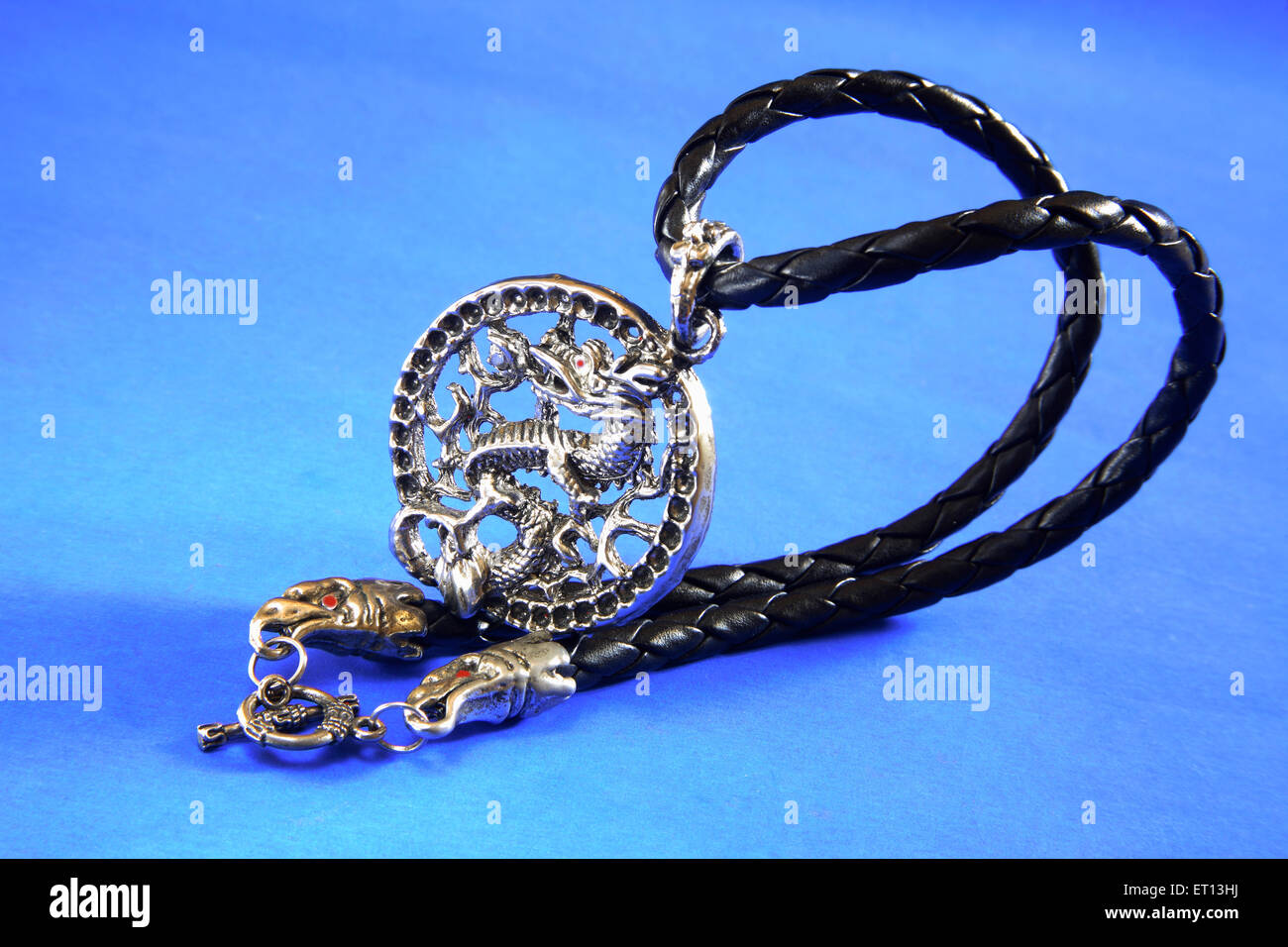 Anhänger Halskette Amulett mit chinesischen Drachen Design auf blauem Hintergrund Stockfoto