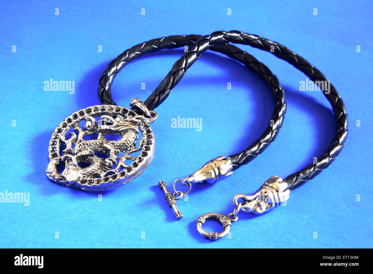 Anhänger Halskette Amulett mit chinesischen Drachen Design auf blauem Hintergrund Stockfoto