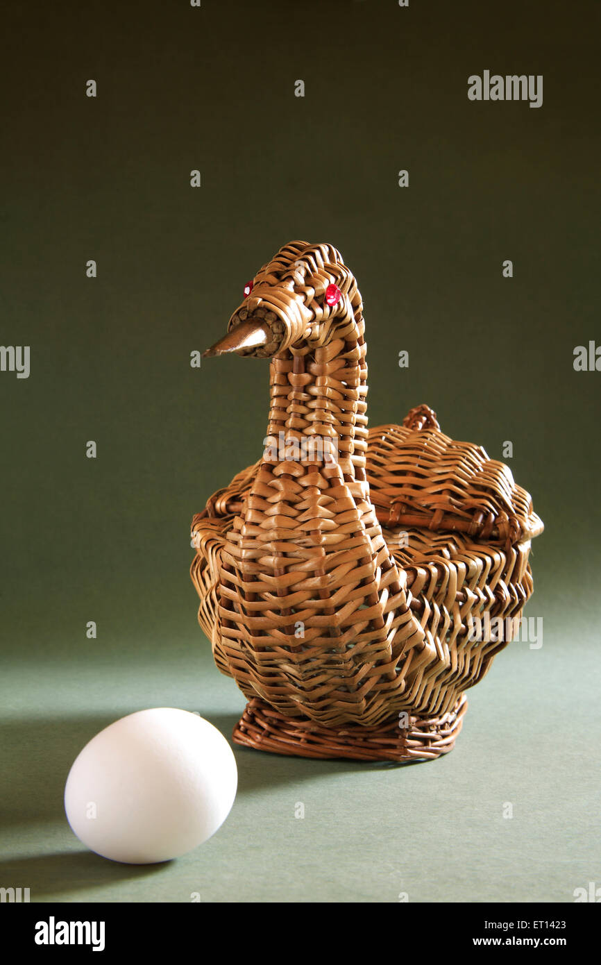 Künstlerische Zuckerrohr Korb Form Ente mit einem Ei auf grünem Hintergrund Stockfoto