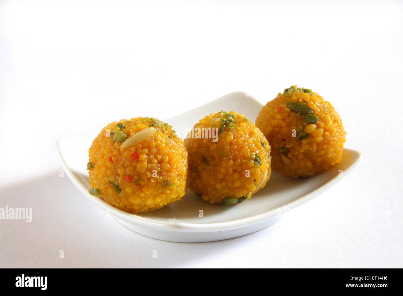 Kozhikode; drei Stücke von Kozhikode Motichur oder Boondi Dryfruit Laddoos in Rechteck Platte auf weißem Hintergrund Stockfoto