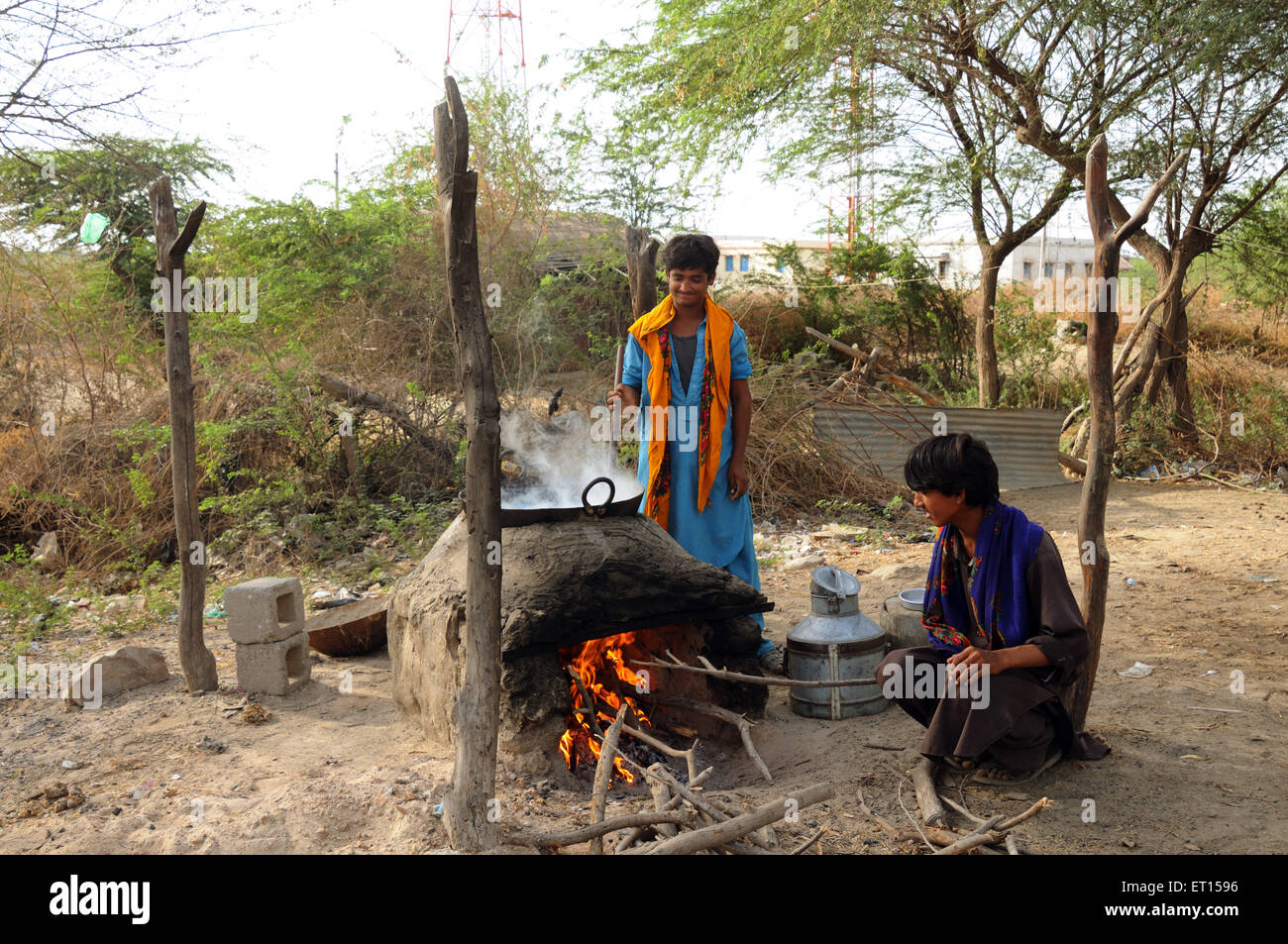 Ländliche Männer, die auf offenem Feuer kochen, Holzofen, Anjar, Kachchh, Kutch, Gujarat, Indien Stockfoto