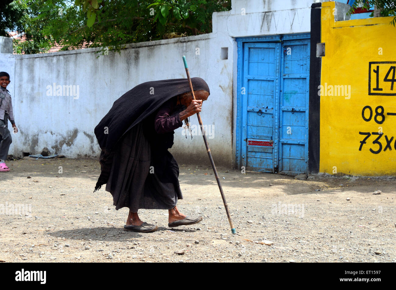 Alte Dame gehen mit Stick am Mindiyada in der Nähe von Anjaar; Kutch; Gujarat; Indien Stockfoto