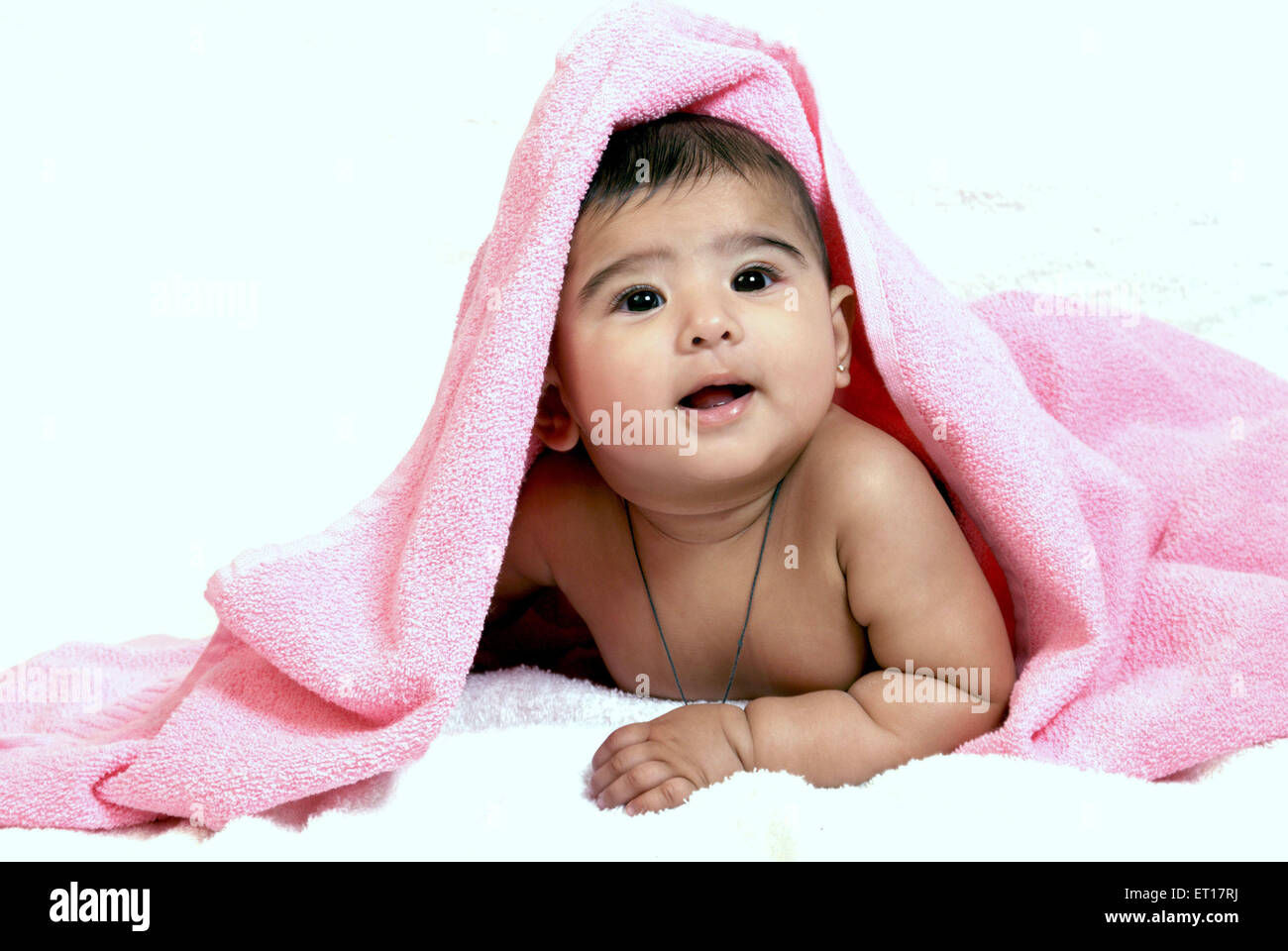 Indische baby Junge Kind Hals Amulett Kopf mit rosa Handtuch liegend auf Bauch Magen suchen auf weißem Hintergrund Herr Nr. 364-Rmm 178217 abgedeckt Stockfoto