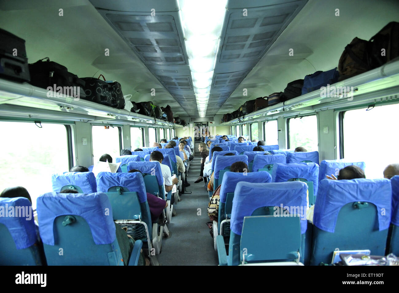 Passagiere sitzen in der Bahn A C Trainer Baroda Express Vadodra Gujarat Indien Stockfoto
