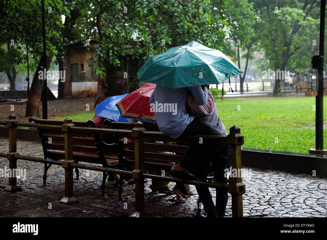 Romanische junges Paar genießen Monsun-Regen im Garten Stockfoto