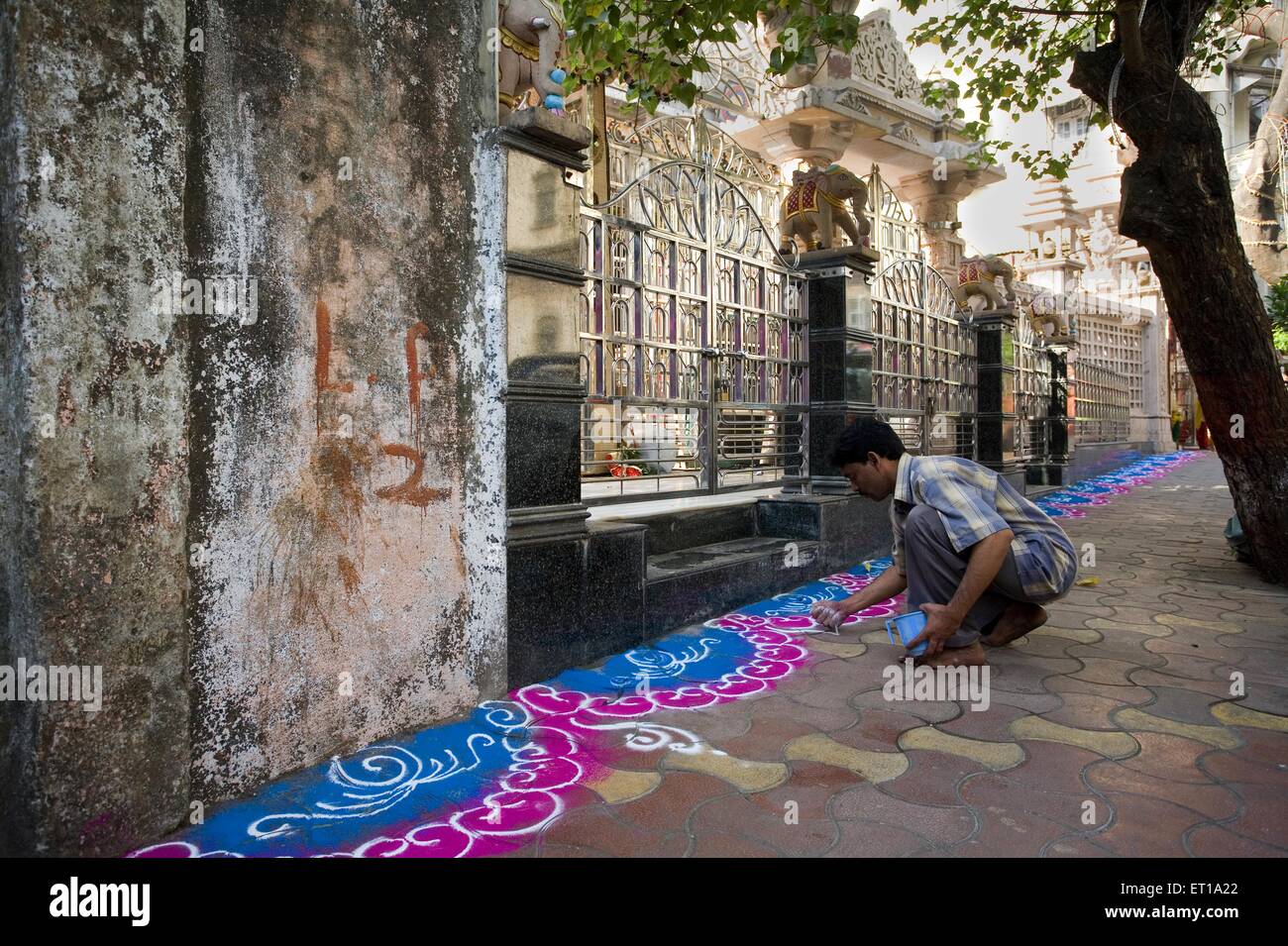 Mann tut Rangoli bunte Bodendekoration außerhalb Jain Tempel für Festival, Bombay, Mumbai, Maharashtra, Indien, Asien, Asien, Indien Stockfoto