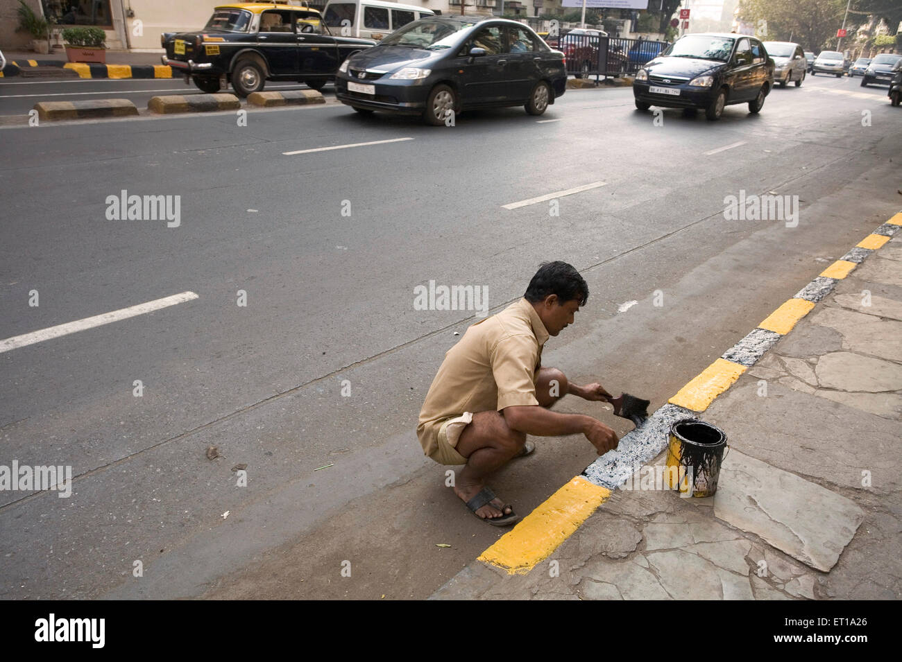 Menschen malen Pflaster Bordstein Stein in schwarz und gelb; Bombay Mumbai; Maharashtra; Indien nicht Herr Stockfoto