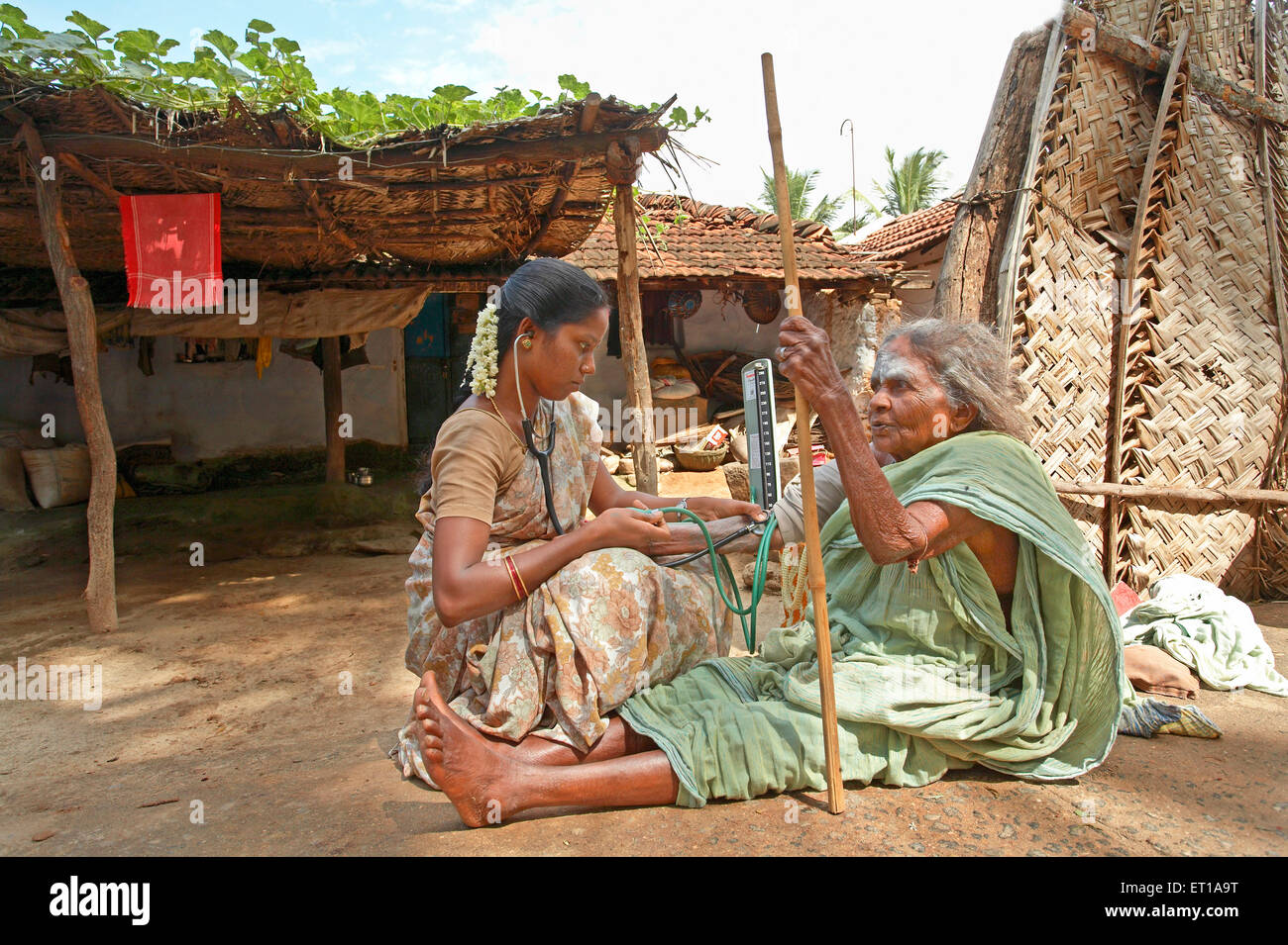 Gesundheitshelfer der NGO Chinmaya Organisation für ländliche Entwicklung KABEL Überprüfung des Blutdrucks Patienten Haustür Siruvani, Palakkad, Kerala, Indien Stockfoto