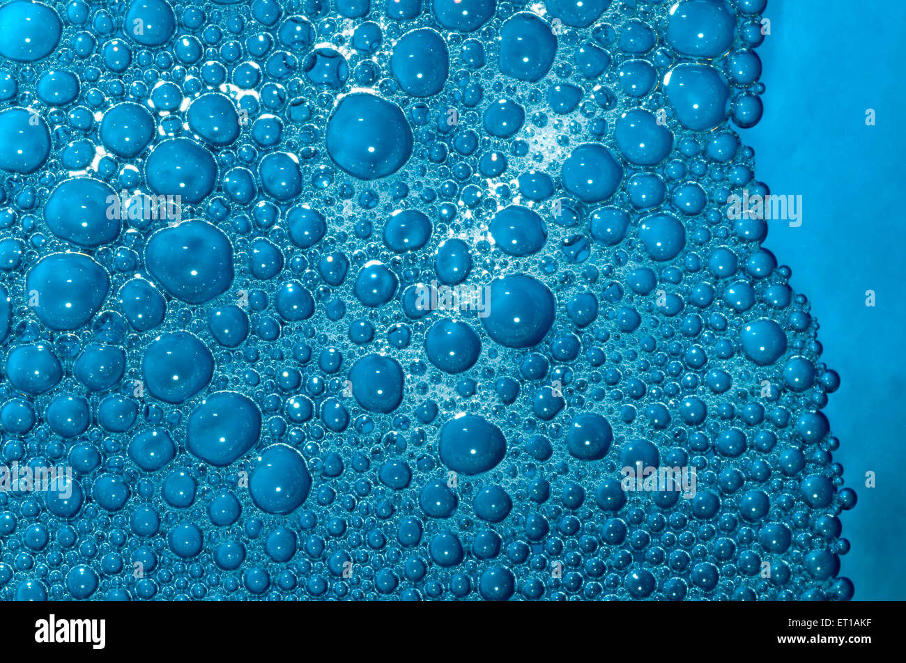 Seife surf Blasen in blau gefärbten Wasser Stockfoto