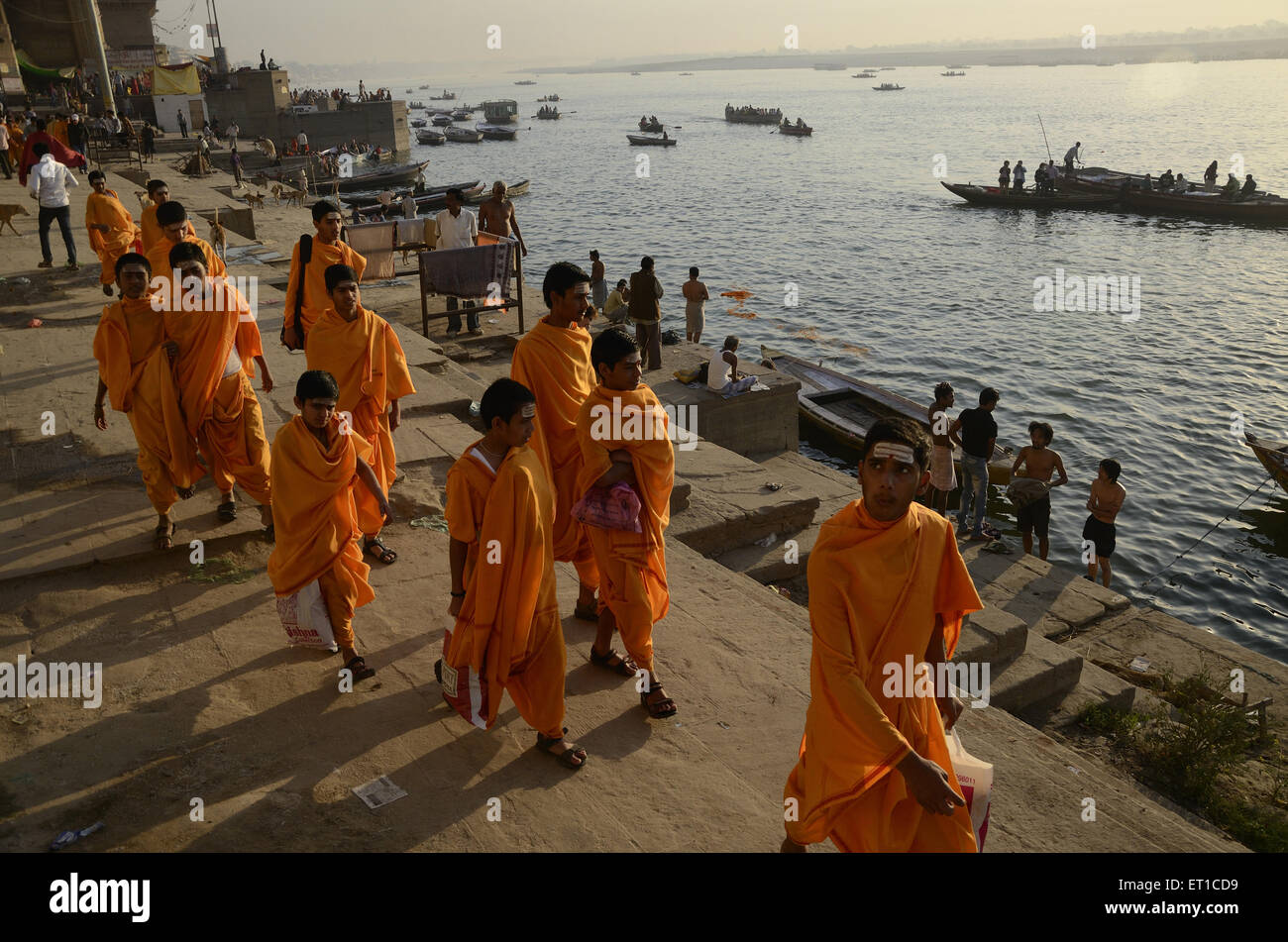 Studenten des Sanskrit Gurukul in Safran-Kostüm zu Fuß auf Varanasi Ghat Uttar Pradesh, Indien Stockfoto