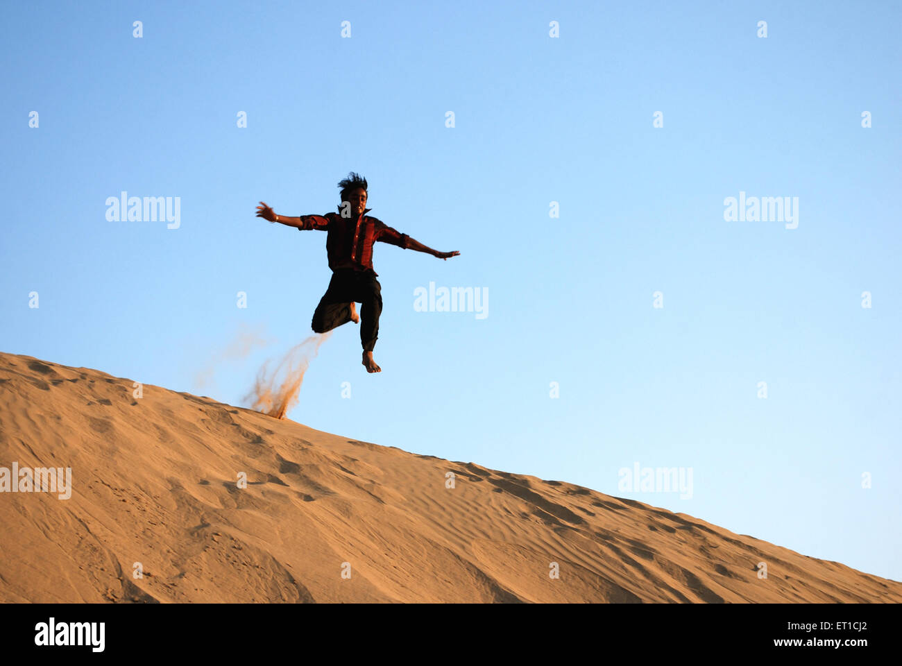 Junge, springen über Sanddüne; Khuri Khuhri; Jaisalmer; Rajasthan; Indien Stockfoto