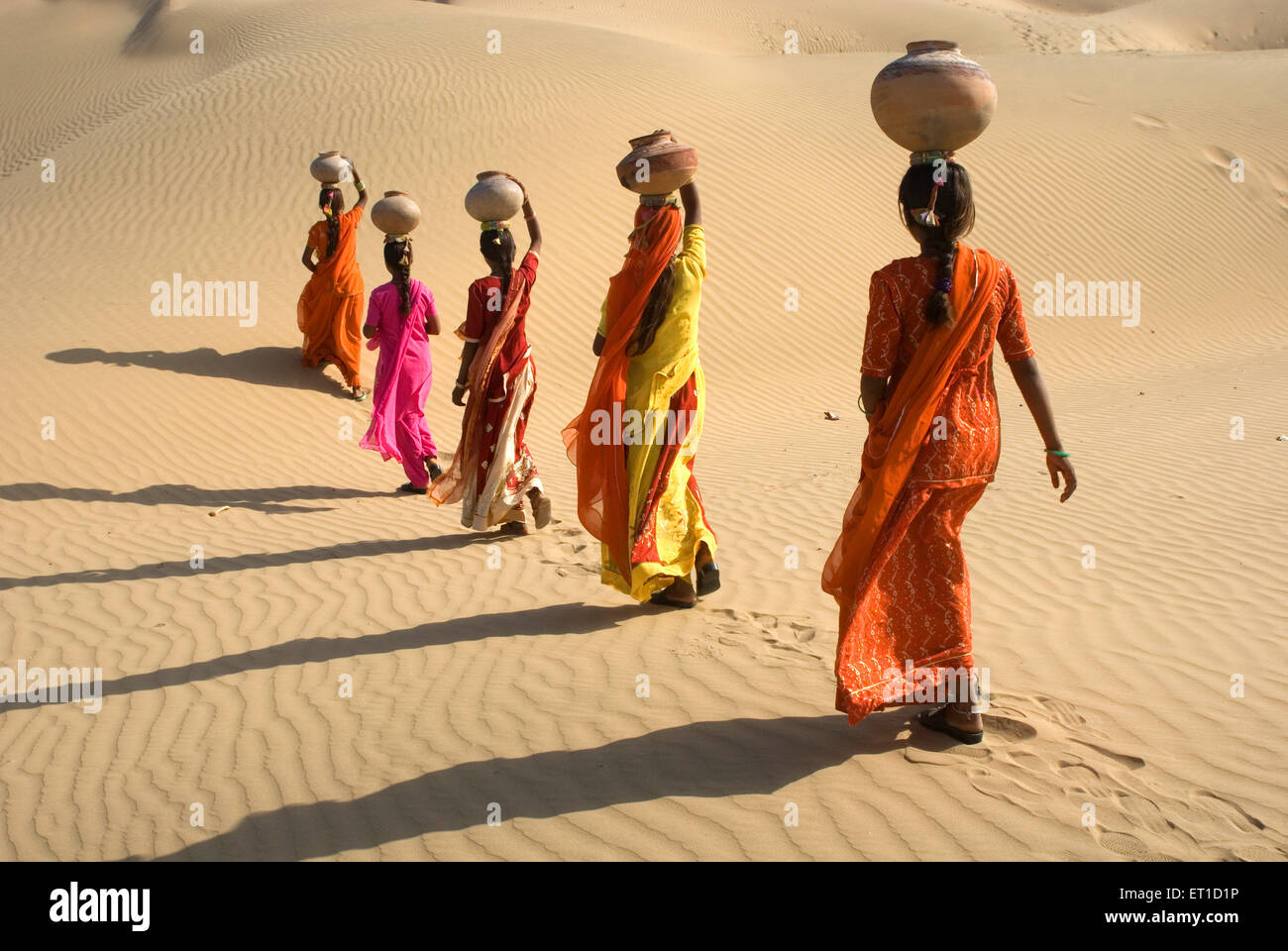 Fünf indische Frauen mit irdenen Töpfe balancieren auf Kopf zu Fuß in Thar Wüste, Khuhri, Jaisalmer, Rajasthan, Indien, Asien Stockfoto