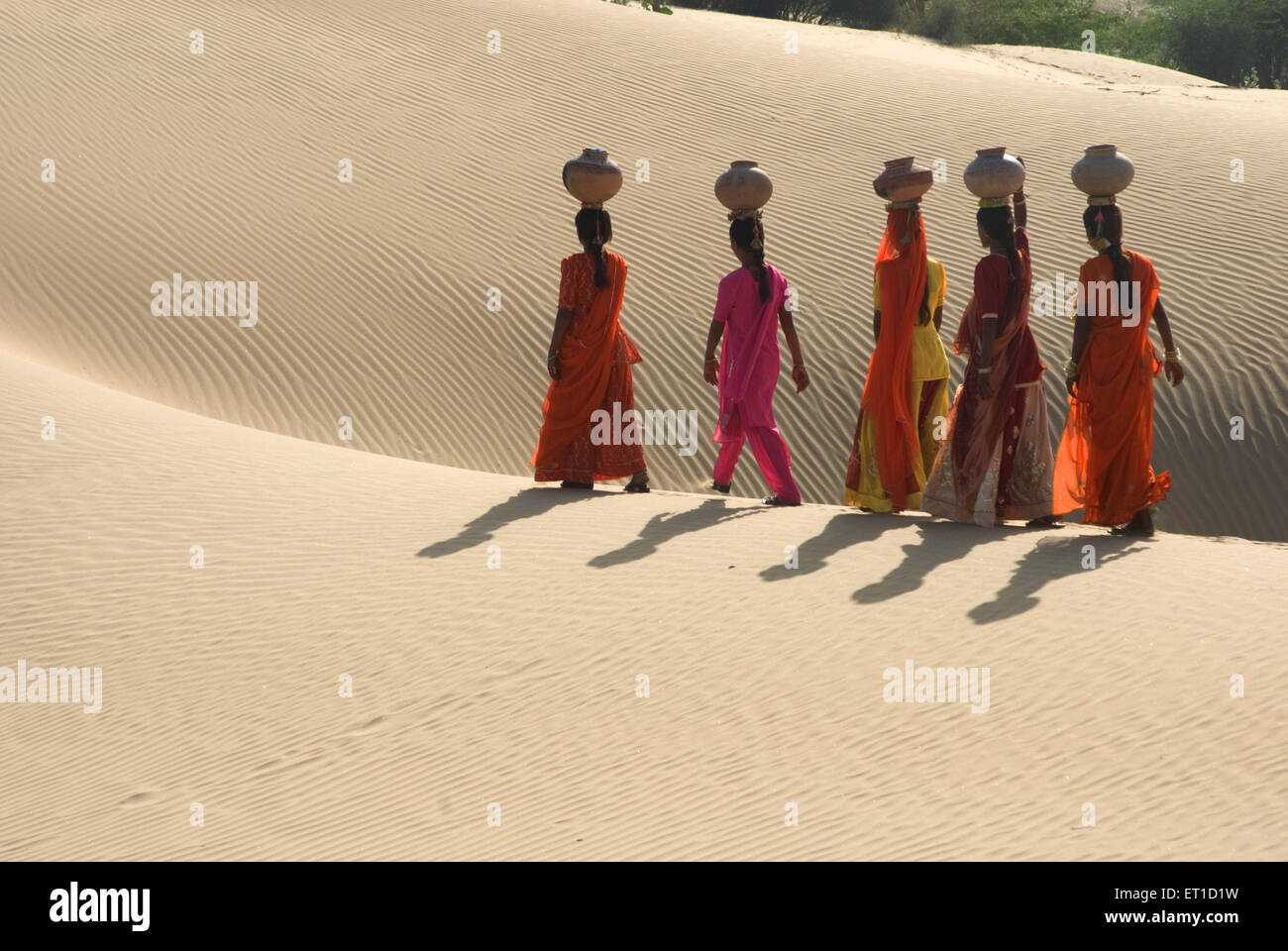 Frauen mit Irdene Töpfe auf Kopf zu Fuß auf Wüste der Khuhri; Jaisalmer; Rajasthan; Indien Stockfoto