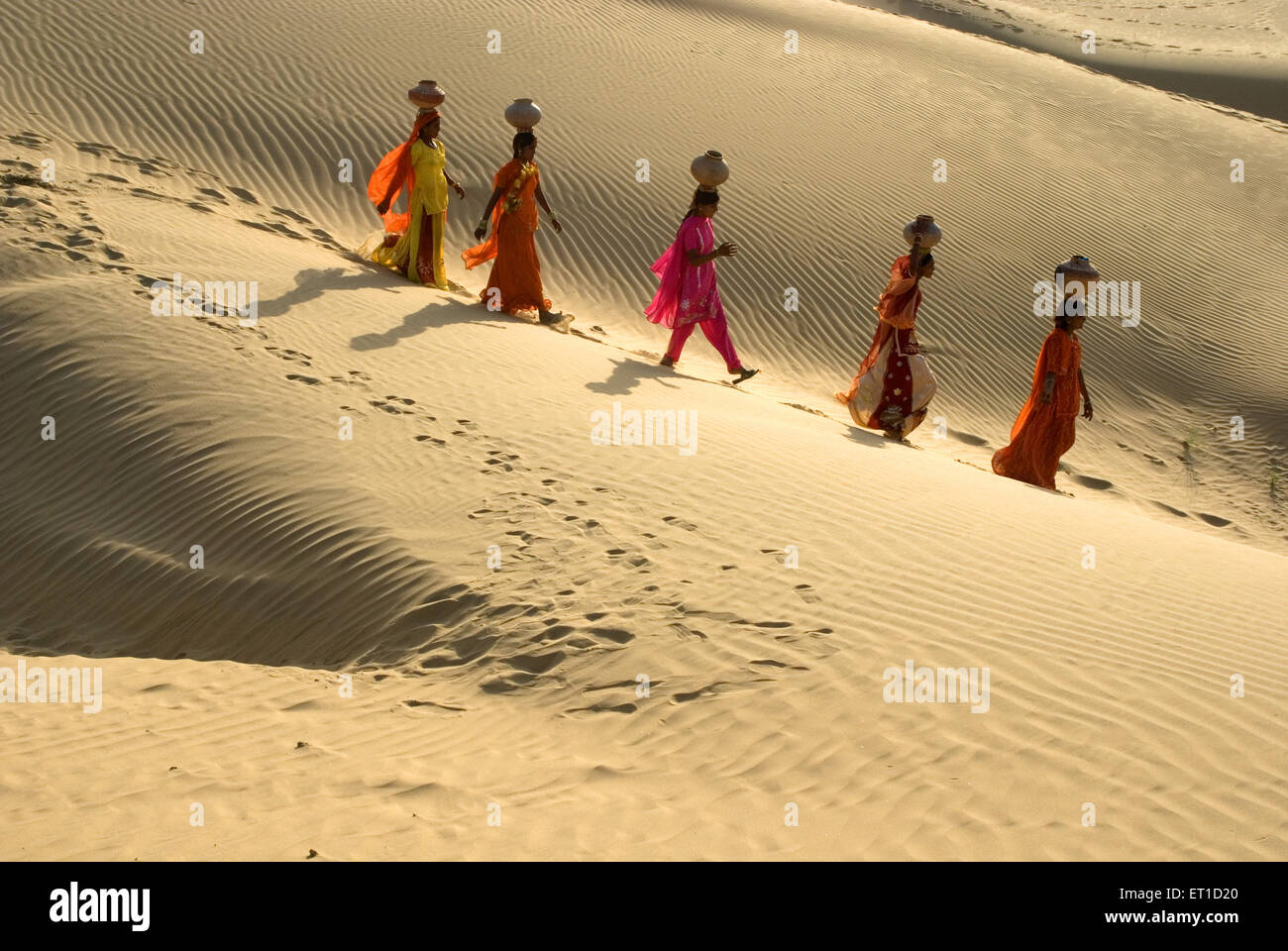 Frauen mit Irdene Töpfe auf Kopf zu Fuß auf Wüste der Khuhri; Jaisalmer; Rajasthan; Indien Stockfoto