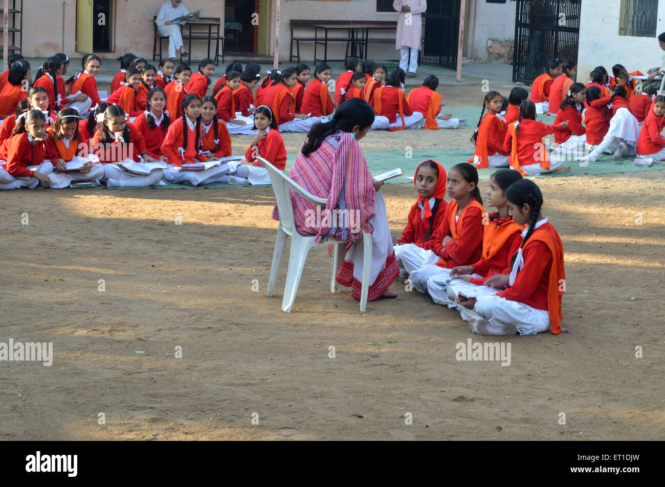Lehrer unterrichten Mädchen sitzen auf offenen Boden Sirohi Rajasthan Indien Asien Stockfoto