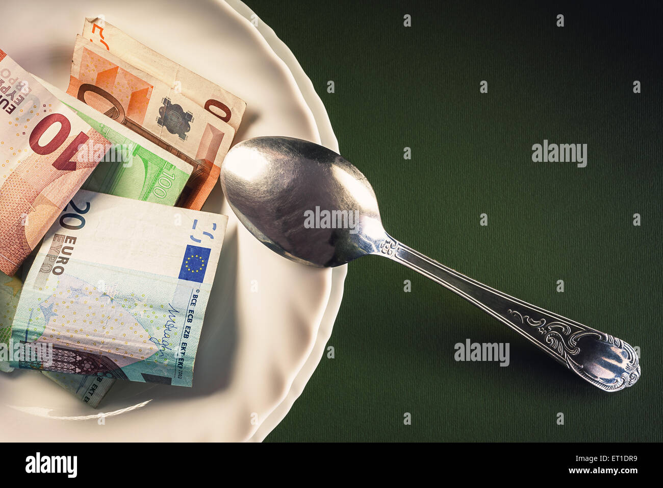 Verschiedenen Euro-Banknoten in weißen Teller mit Löffel auf einer Seite, konzeptuelle Komposition über Geld. Stockfoto