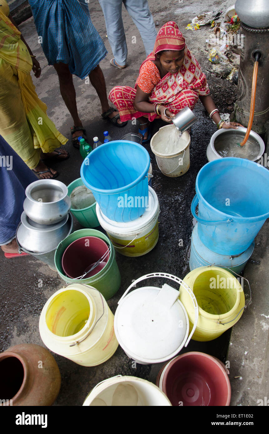 Frau, die Wasser aus öffentlichen Wasserhahn Kolkata West Bengal Indien Asien Stockfoto