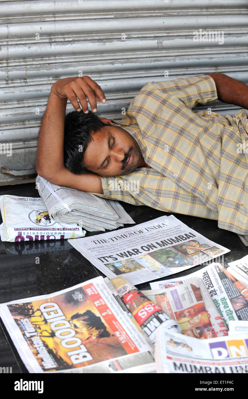 Mann schläft; Zeitungen Artikel über Terroranschlag von Deccan Mudschaheddin am 26. November 2008 in Bombay Mumbai Stockfoto