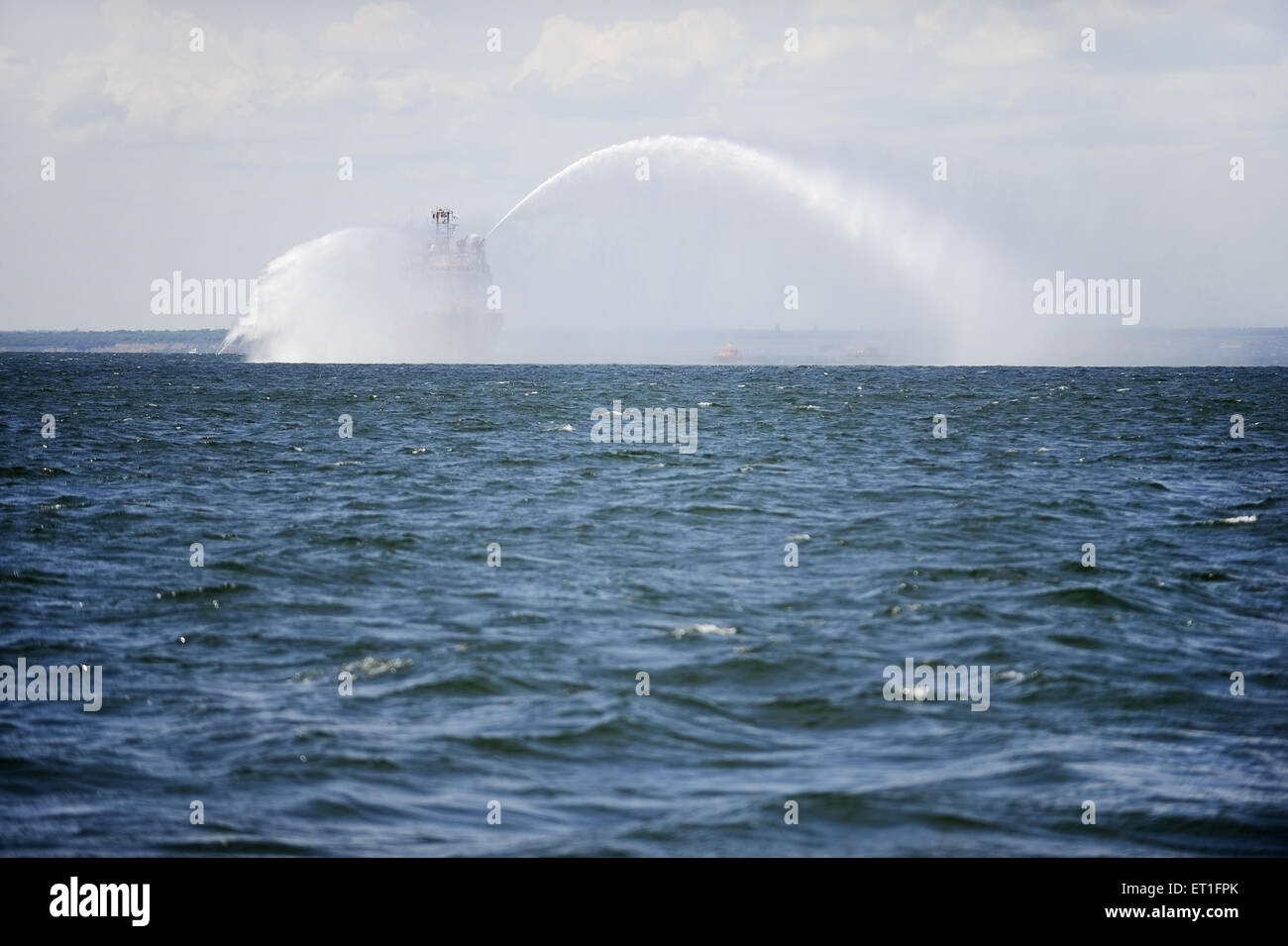 Ein Löschboot sprüht Wasser in die Luft während einer Meer-drill Stockfoto