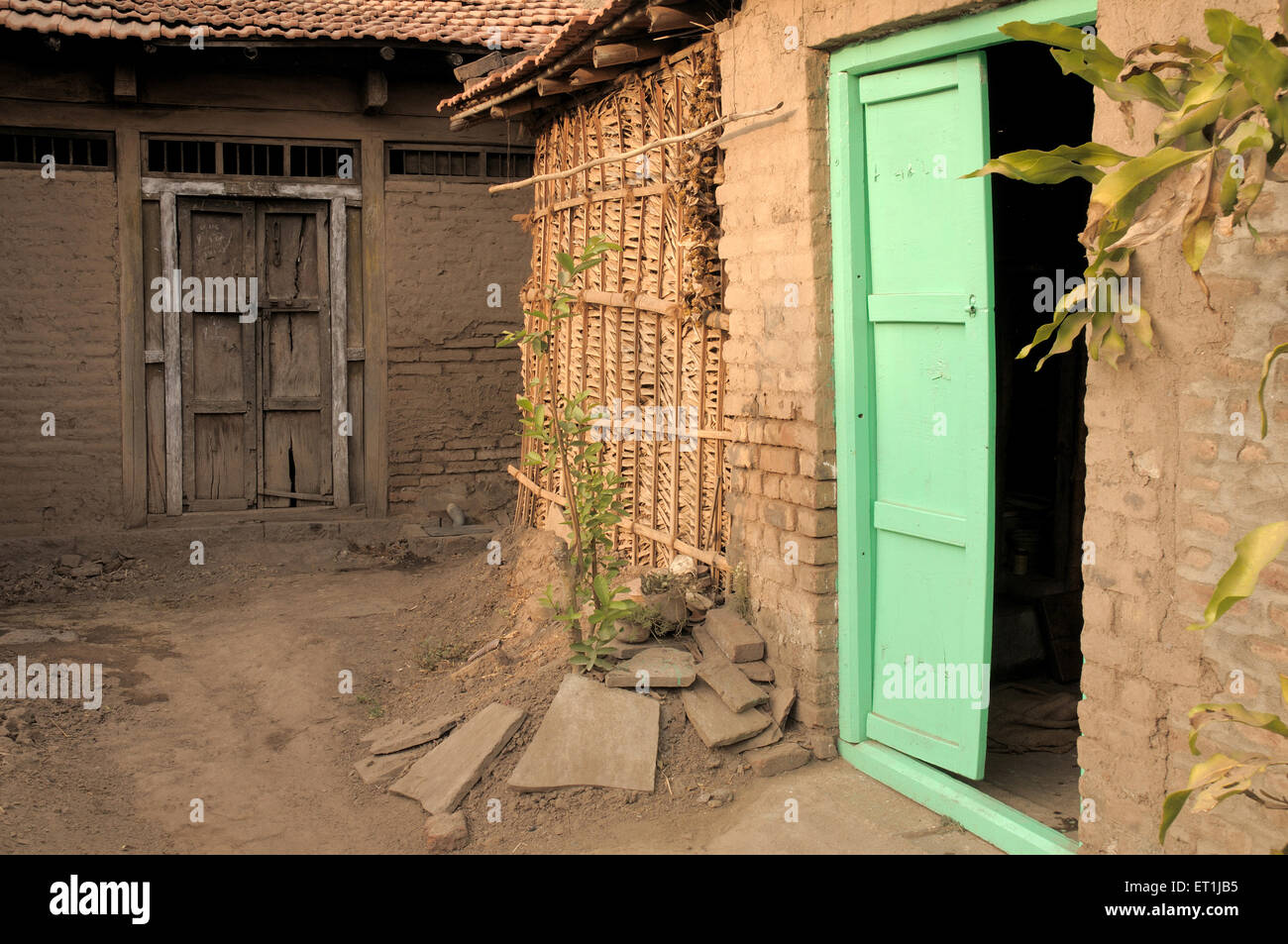 Offene Holztür und geschlossene Holztür Hütte mit Kuh-Dung strohgedeckten Wand ; Khidrepur ; Kolhapur ; Maharashtra ; Indien ; Asien Stockfoto
