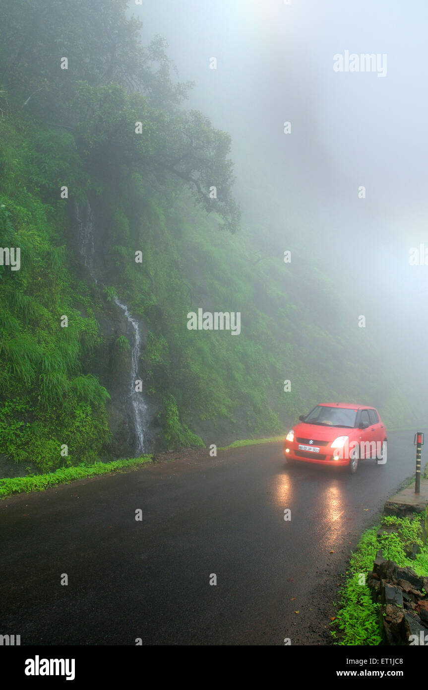 Rotes Auto in der Nähe von winzigen Wasserfall; Mahabaleshwar; Maharashtra; Indien Stockfoto