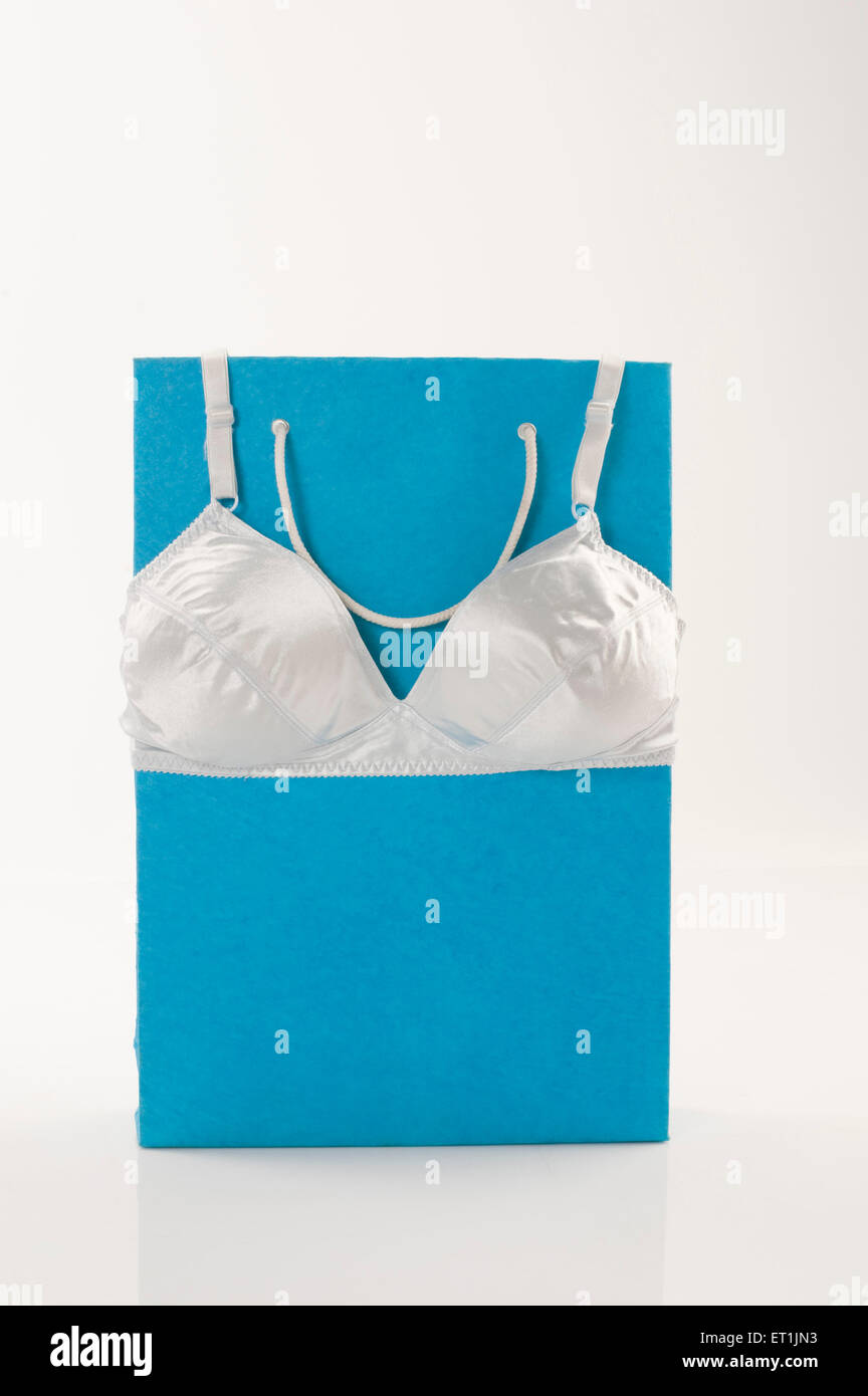 Eine Einkaufstasche aus blauem Papier mit weißem BH-Unterkleid für Frauen Stockfoto
