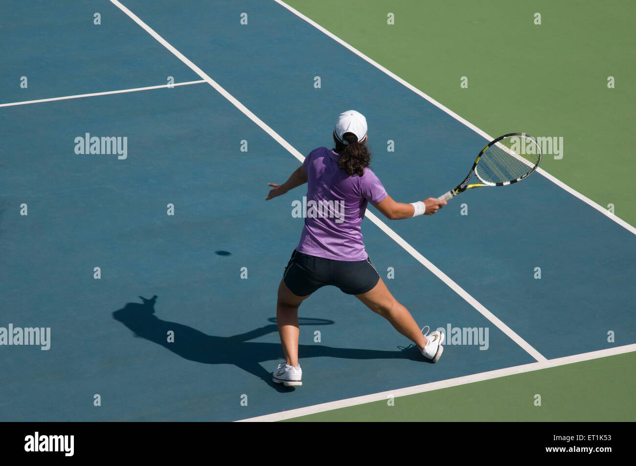 Eine Frau, die Tennis spielt und sich im Vorfeld trifft Stockfoto