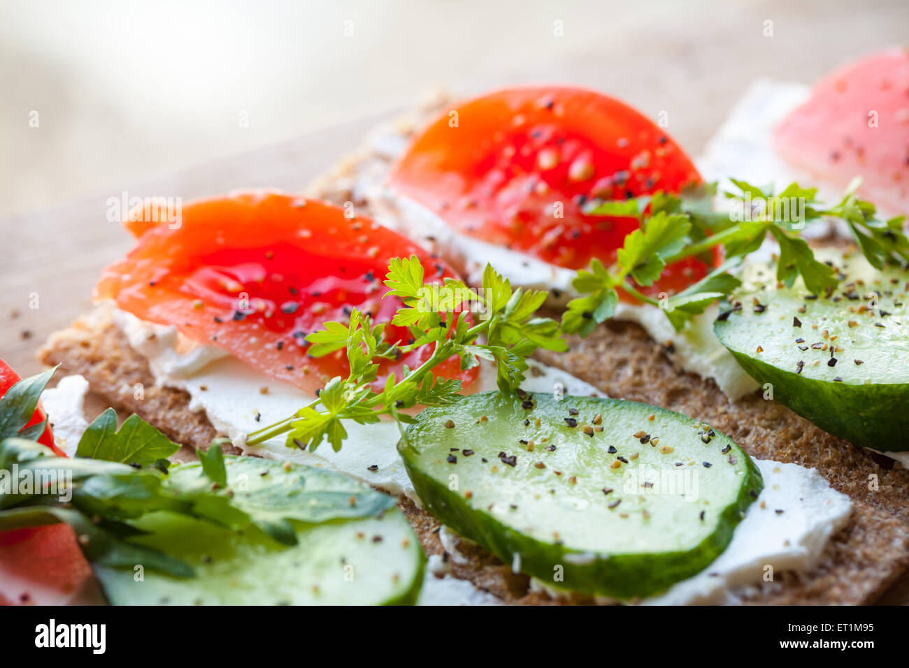 Gesunde Ernährung-Thema. Sandwiches gemacht der finnischen Roggen Knäckebrot, Weichkäse, Gurken, Tomaten, Petersilie und Pfeffer Stockfoto