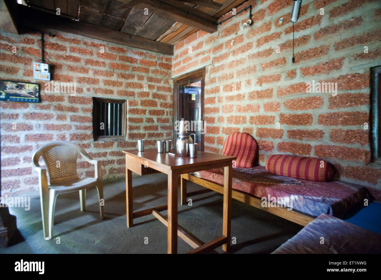 Holztisch, Plastikstuhl, ländliches Dorfhaus; Maharashtra; Indien; Asien Stockfoto