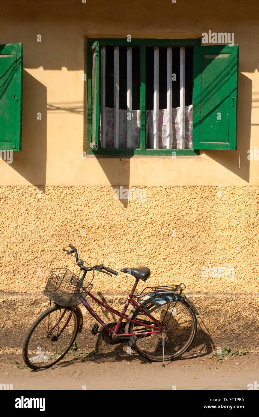 Fahrrad, das an der Wand mit Fenster geparkt ist; Cochin; Kochi; Kerala; Indien; Asien Stockfoto