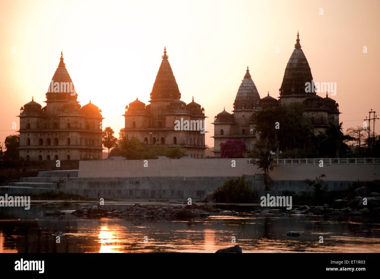 Sonnenuntergang mit Kenotaphen am Ufer des Flusses Betwa; Orchha; Tikamgarh; Madhya Pradesh; Indien Stockfoto