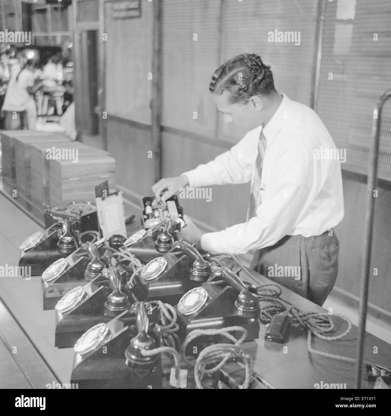 Mann Montage von Telefoninstrumenten; Telefonfabrik; Herstellung von Telefoninstrumenten Bangalore; Karnataka; Indien; Asien; alter Jahrgang 1900 Stockfoto