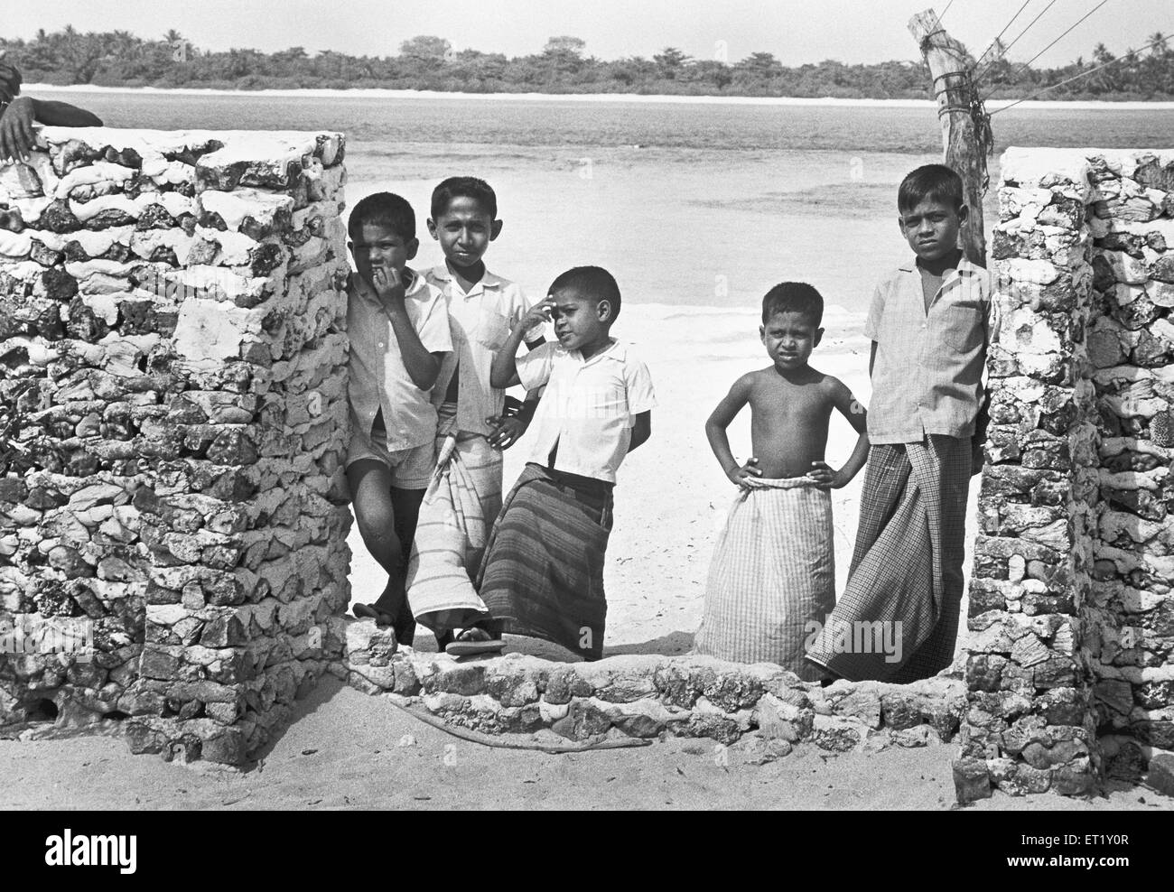 Fünf Kinder stehen zusammen in lungi und Händen an verschiedenen Orten; Männlich; Malediven; Arabisches Meer; Indischer Ozean; Asien; alter Jahrgang 1900er Stockfoto