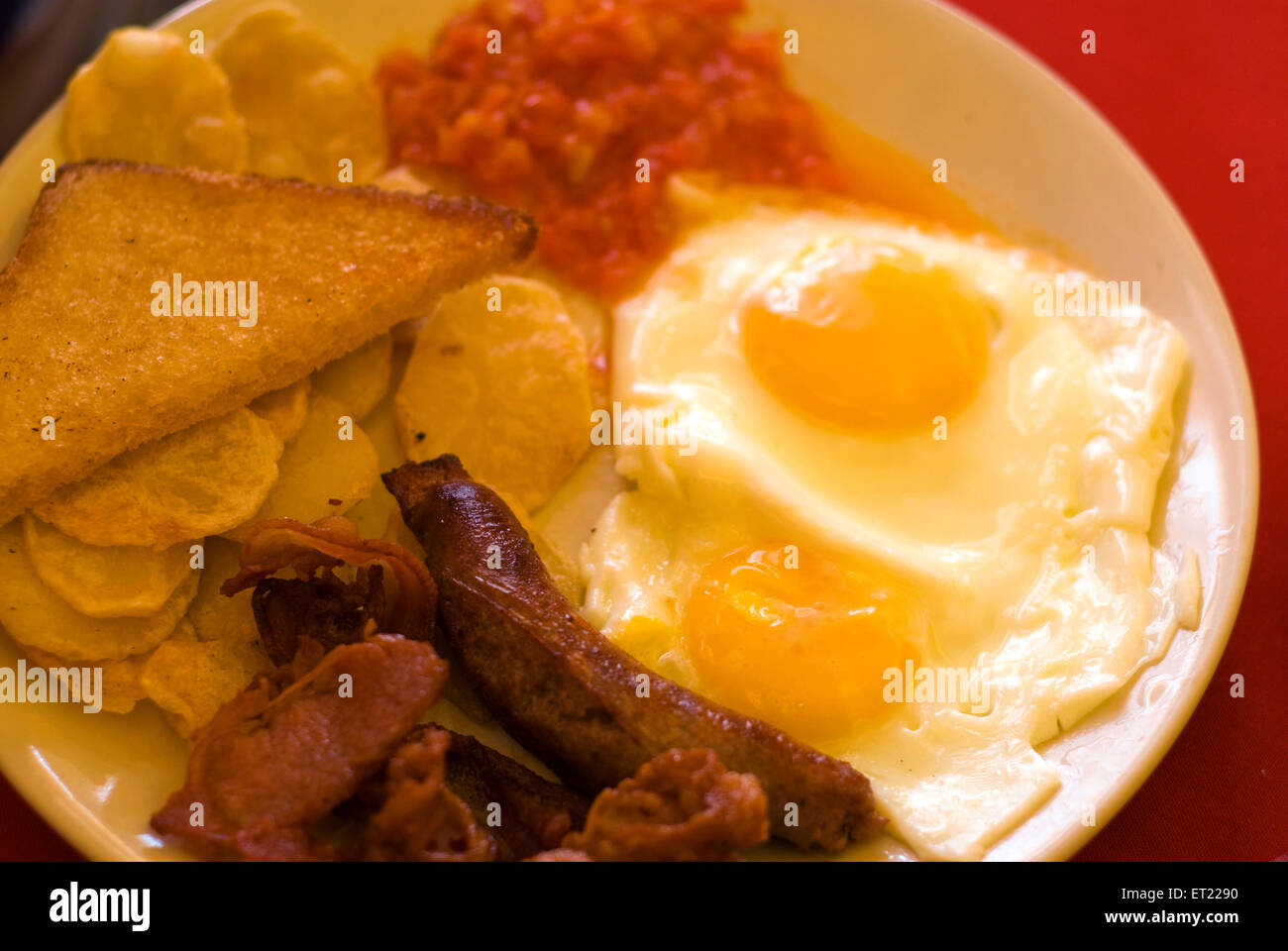 Englisches Frühstück; Schinken gebraten Eiern geröstetes Brot am roten Tisch; Goa; Indien Stockfoto