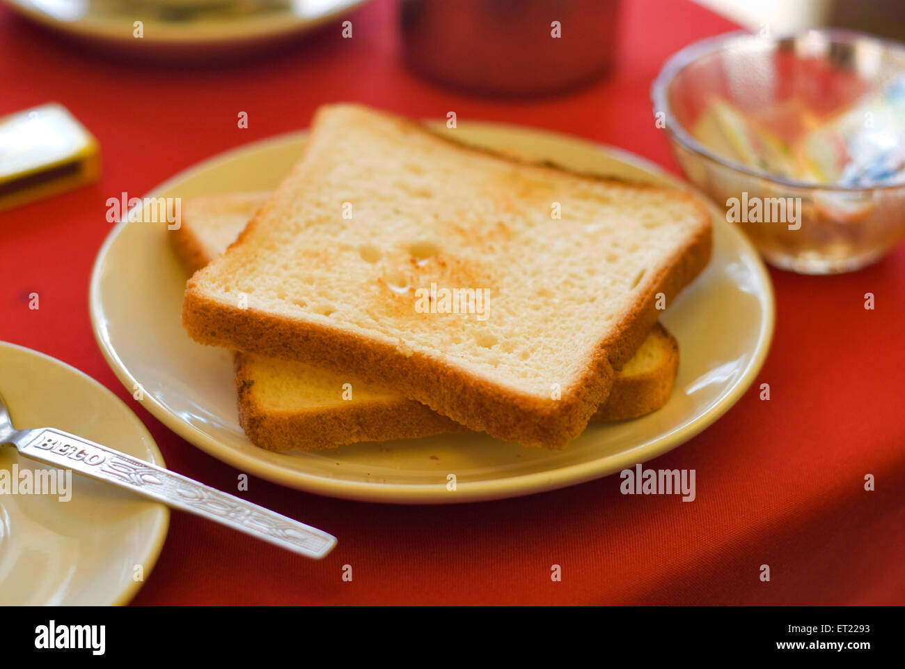 Geröstetes Brot in Platte auf roten Tisch gelegt; Goa; Indien Stockfoto