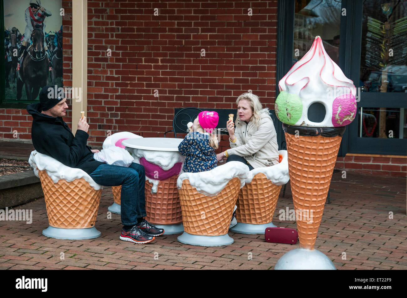 Familie von drei essen Eiscreme, sitzen in den übergroßen "Zapfen" bei Daylesford, Victoria Stockfoto