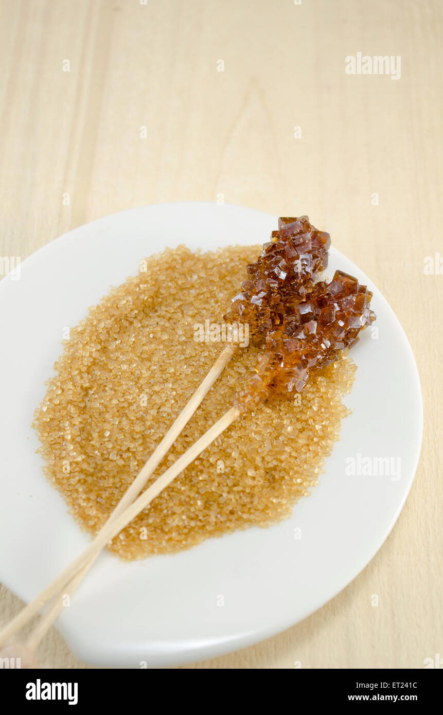 Zwei Zuckersticks mit weißen und braunen Zucker in einem weißen Teller Stockfoto