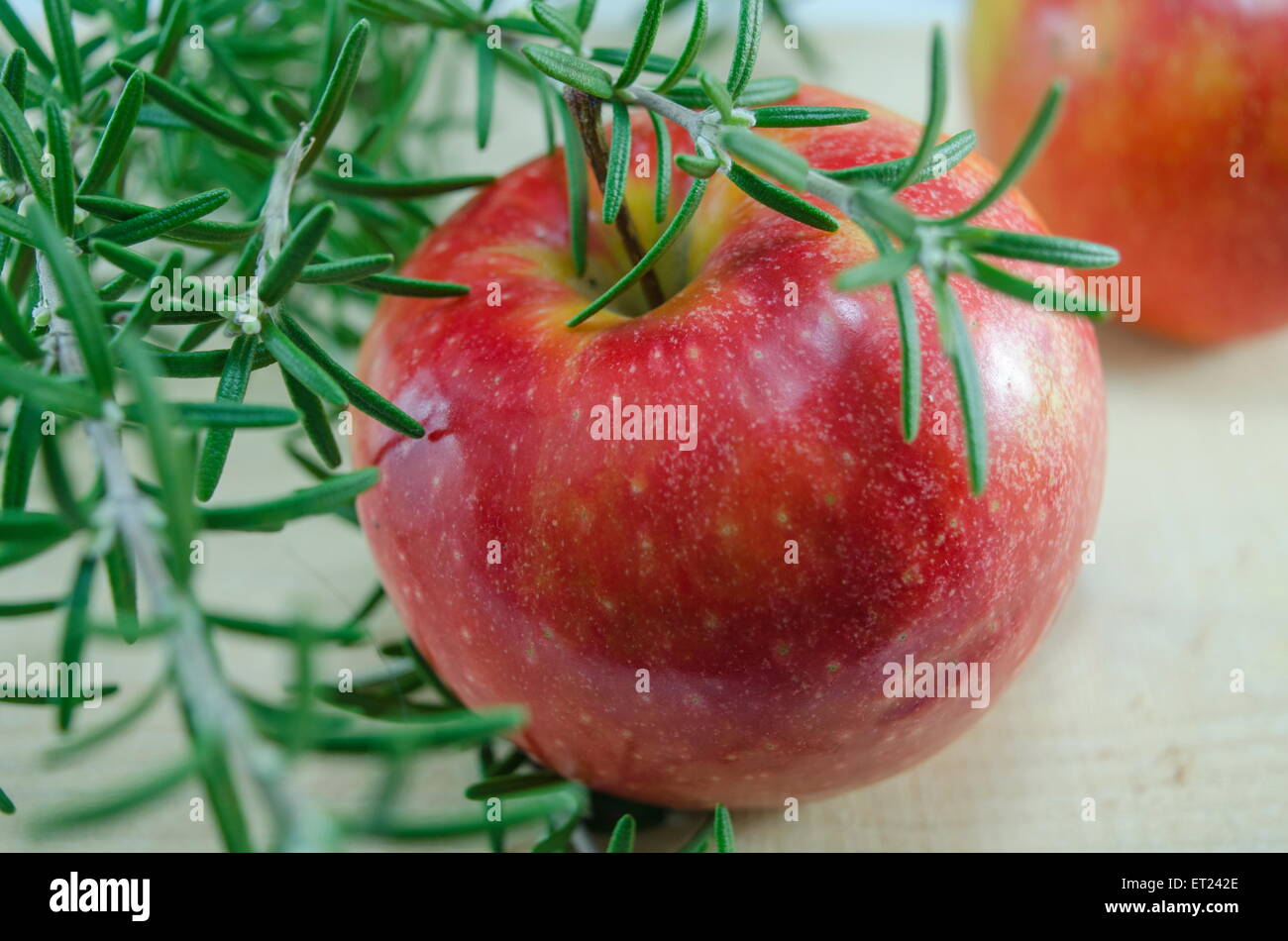 Frischen roten Äpfeln und Rosmarin auf einem Holztisch Stockfoto