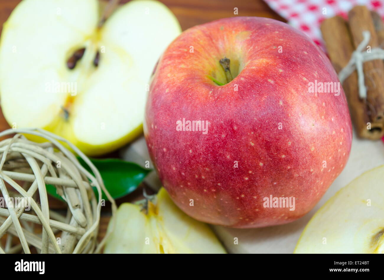 Halbierte und ganzen roten Apfel auf einem Tisch mit einer handgefertigten Dekoration Stockfoto