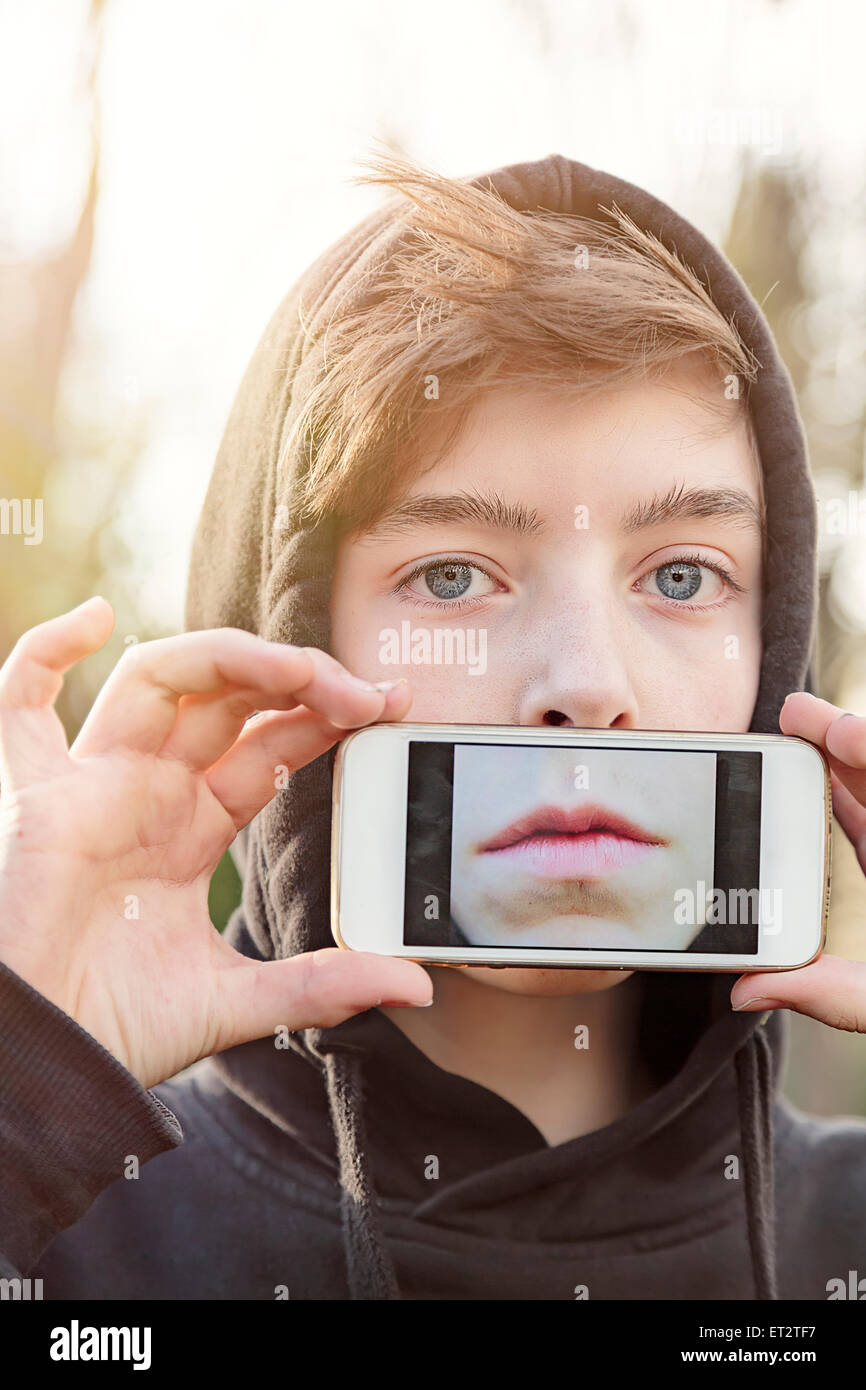 virtuelle Immobilien, Teenager, die eine Smartphone vor seinem Gesicht halten Stockfoto