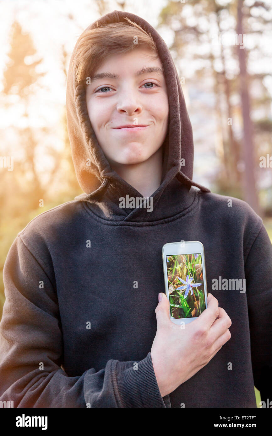 virtuelle Immobilien, Teenager halten ein smart Phone vor seinem Herzen Stockfoto