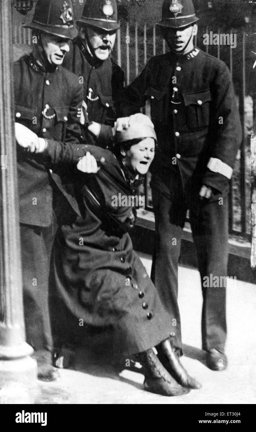 Eine Frauenrechtlerin wird von drei Polizisten zurückgehalten. Ca. 1912. Stockfoto